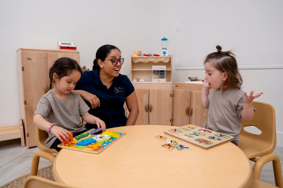 A Gan teacher working with children at a table
